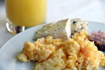 Scrambled eggs, pate,cheese and orange juice for breakfast