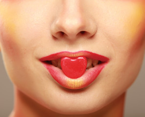 Naklejka premium A beautiful woman is holding a symbol of a heart