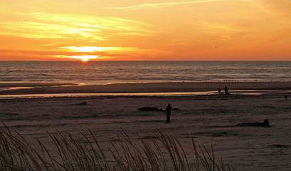 Bright Orange and Golden Sunset with a Family at the Beach