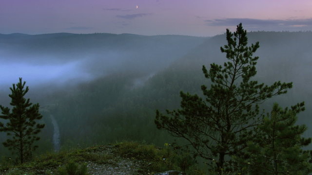 timelapse fog rising up above night forest, view from highland