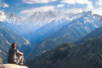Foto op Canvas De zakenman op de top van de berg die zit en nadenkt © petunyia