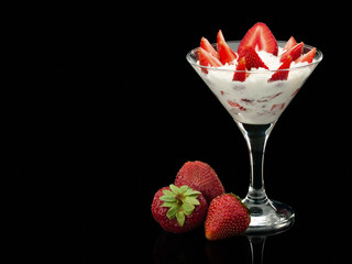 Strawberry whole and with cream in a glass