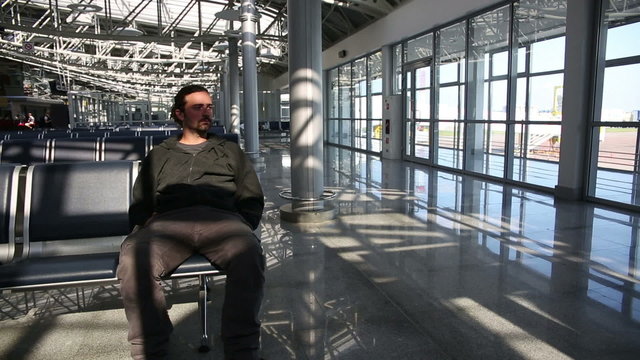 young man waiting his flight in airport lounge