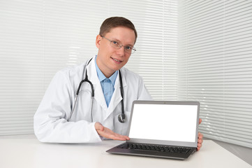 young doctor in lab coat with laptop