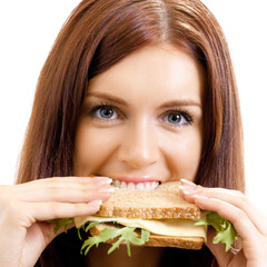 Cheerful woman eating sandwich with cheese