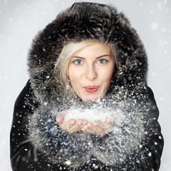 Nice lady dressed in warm winter coat breathalysing snow