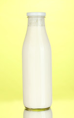 bottle of milk on yellow background close-up