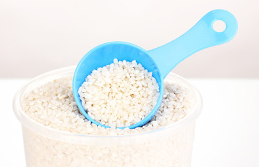 Measuring spoon and plastic container with grain isolated