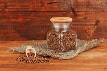 Flax seeds in wooden spoon on wooden background close-up