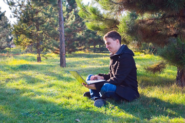 Businessman working on laptop in the park