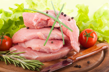 Raw meat with rozmarinom and tomatoes on a wooden board