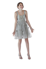 Teenage girl in lace party dress laughs and shrugs