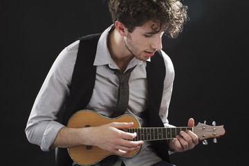 Closeup of young man playing a ukelele