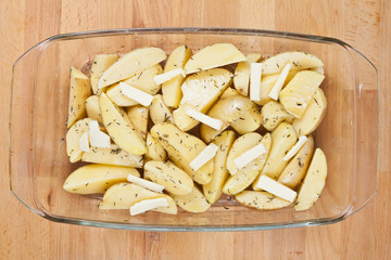 Raw potatoes in a glass tray, ready to be roasted
