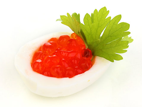 Red caviar in egg isolated on white