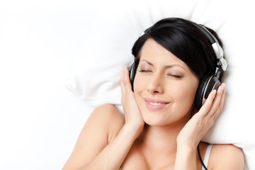 Naklejka premium Woman in underwear listens to music through the black headphones
