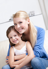 Smiley mother embraces her lovely daughter