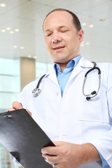 medical doctor writing on clipboard