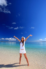 澄んだ美しい海と両手を広げる女性