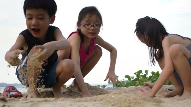 Asian Siblings playing Sand