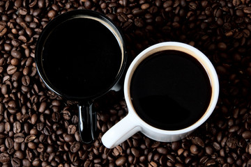 Two coffe mugs on coffe beans