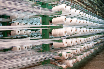 bobbin thread cones on a warping machine in a textile mill.