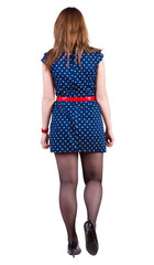 back view of walking young  woman