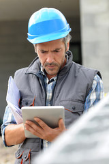 Entrepreneur on construction site using electronic tablet