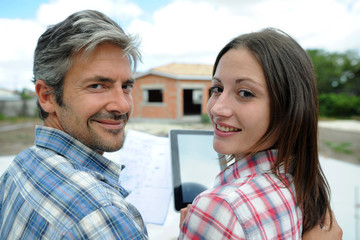 Fototapeta premium Couple standing in front of their future home