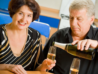 Cheerful senior couple celebrating with champagne