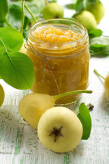 Pear jam in a glass jar and fresh fruits with leaves