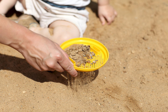 Sifting sand in sandbox