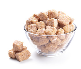 glass bowl full of cane sugar isolated on white