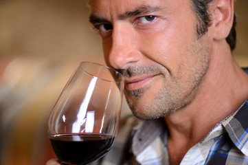 Closeup on winemaker smelling red wine in glass