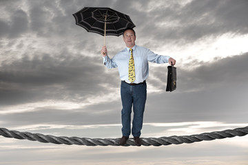 Business man balancing on the rope