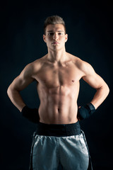 Fototapeta premium Sportsman boxer intense portrait against black background.