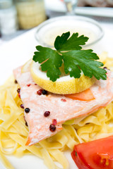 close-up of plate of pasta and smoked salmon with tomato