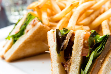 Sandwich with chicken, cheese and golden French fries potatoes