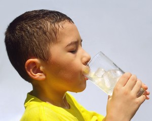 kid sipping lemonade, sweating hot under direct sunl