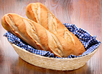 Bread French baguettes in basket on wood
