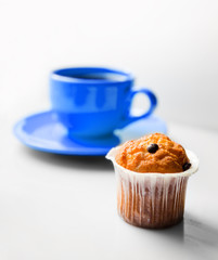 .Coffee in a blue cup and a muffin