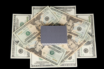 Dollars and a deck of playing cards isolated on black