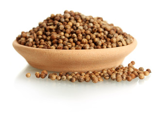 Heap coriander seeds in clay bowl isolated on white
