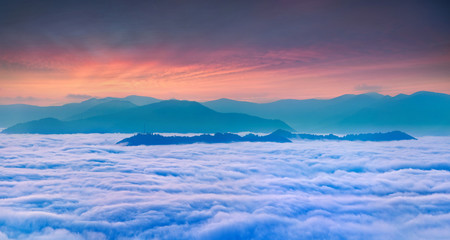 Sunrise over the sea of fog in the mountains at the summer
