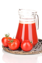 Tomato juice in pitcher on wicker mat isolated on white