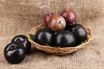 Rip plums on basket on sacking