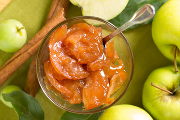 Apple jam with cinnamon and fresh fruits with leaves