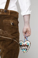 R&uuml;ckansicht von Mann in Lederhose mit Lebkuchenherz "Schatzi"