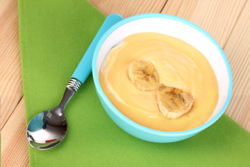 Yogurt with banana on wooden table