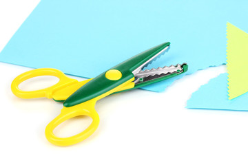 Colorful zigzag scissors with color paper isolated on white